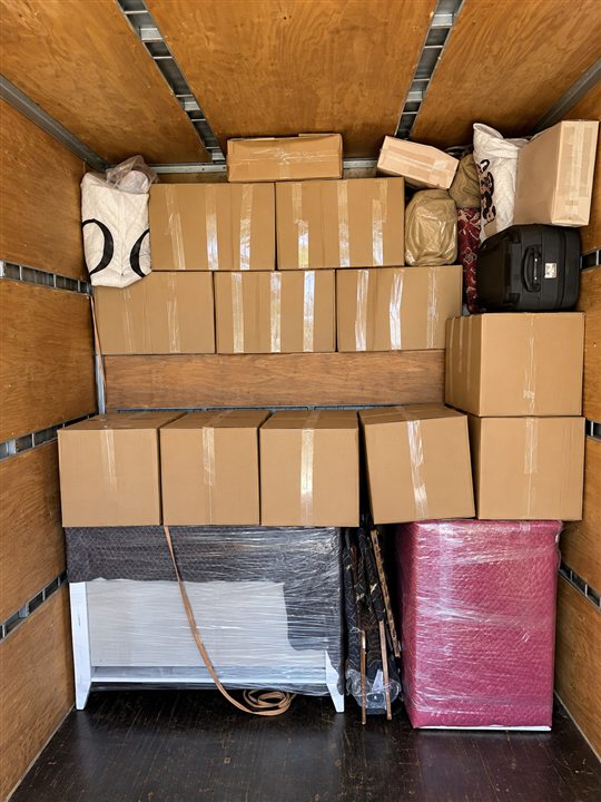 Araç içinde istiflenmiş koliler ve paketli eşyalar — yeniden oluşturulmuş görsel